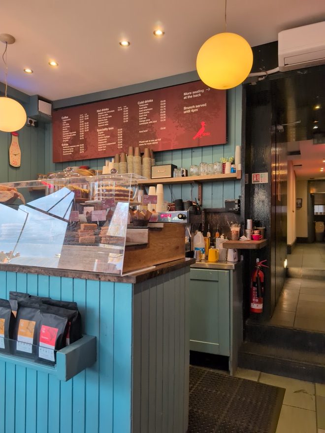 The counter and menu boards from the side under globe pendant lights