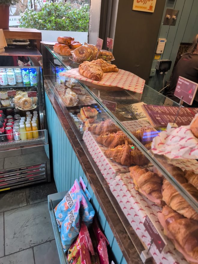 The glass display case full of croissants and pastries