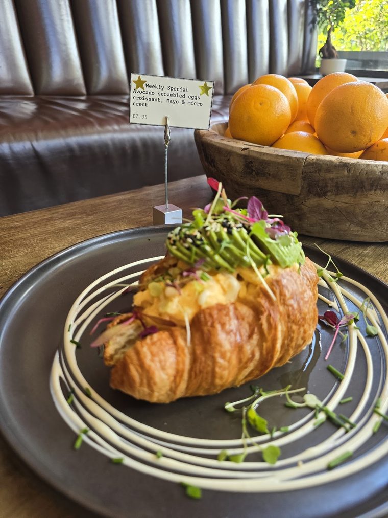 Cheese-filled croissant plated with micro-herbs